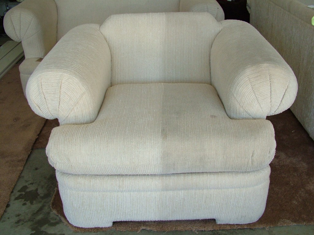 White upholstered chair partially cleaned, showing the visible difference between cleaned and uncleaned fabric